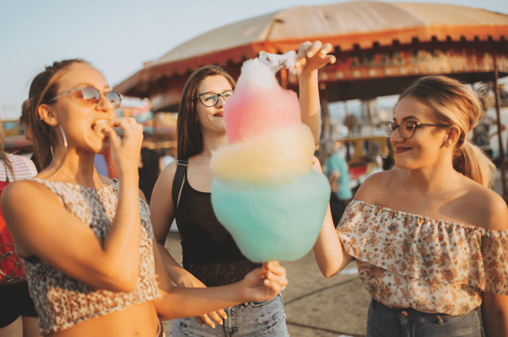 3 girls at the fair eating cotton candy