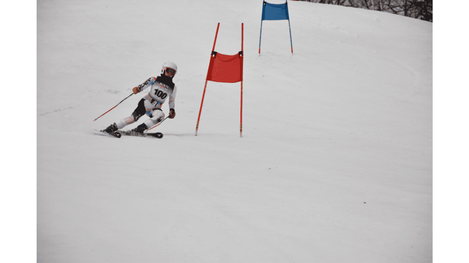 Skier racing through slalom gates during the Ski Brule Thanksgiving Ski Race Camp in Iron County, Michigan.