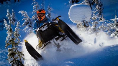 mid air snowmobile jump in deep snow
