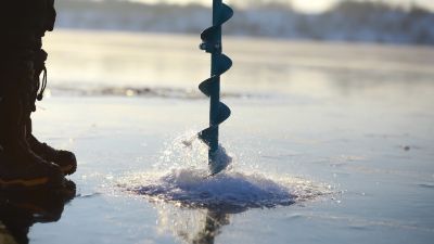 ice augur drilling into a frozen lake