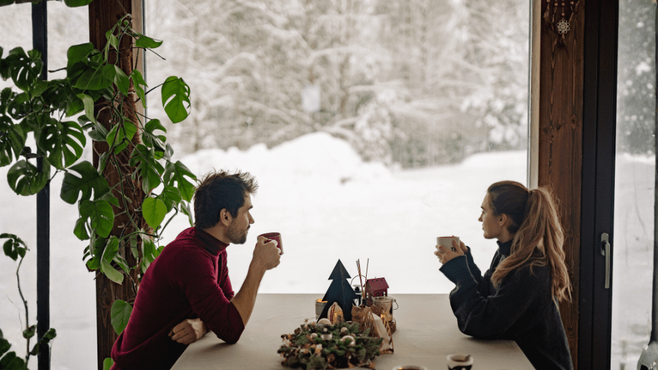 a couple enjoying a winter scenery inside of a restraunt