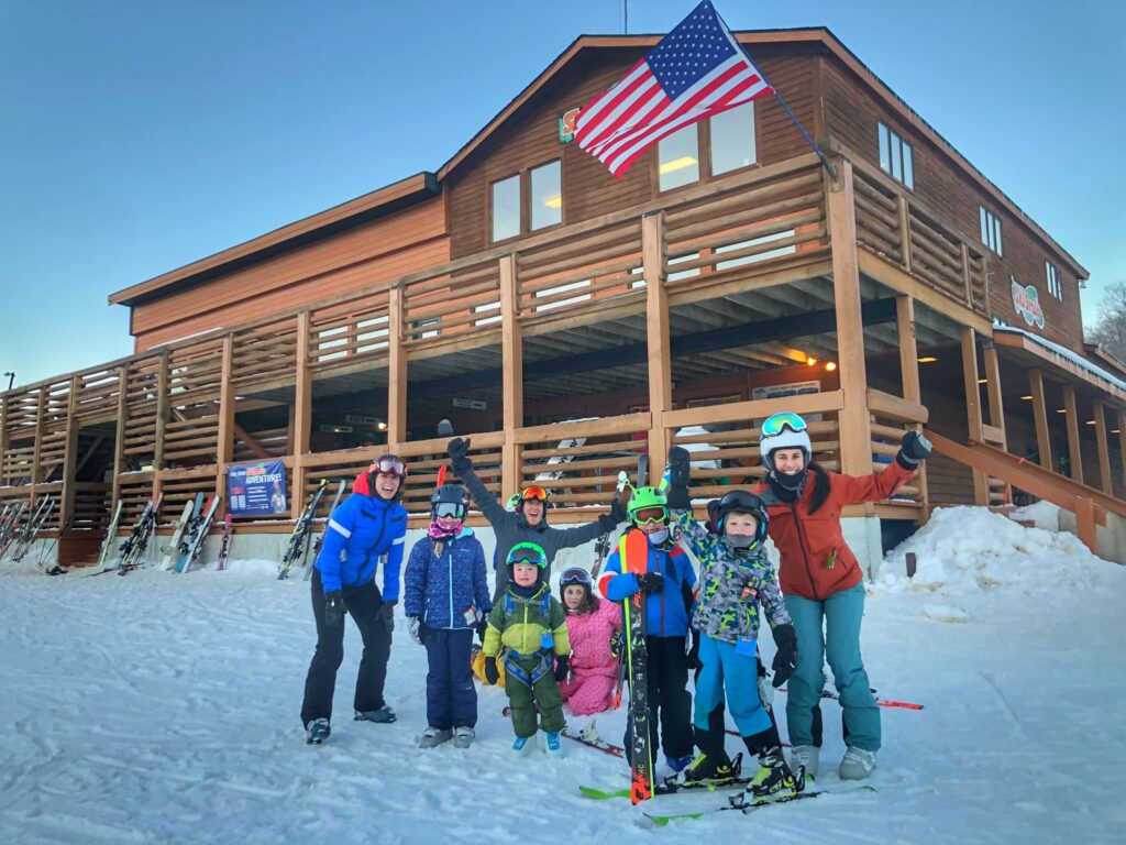 Moms in kids infront of ski Brule looking jolly in full gear