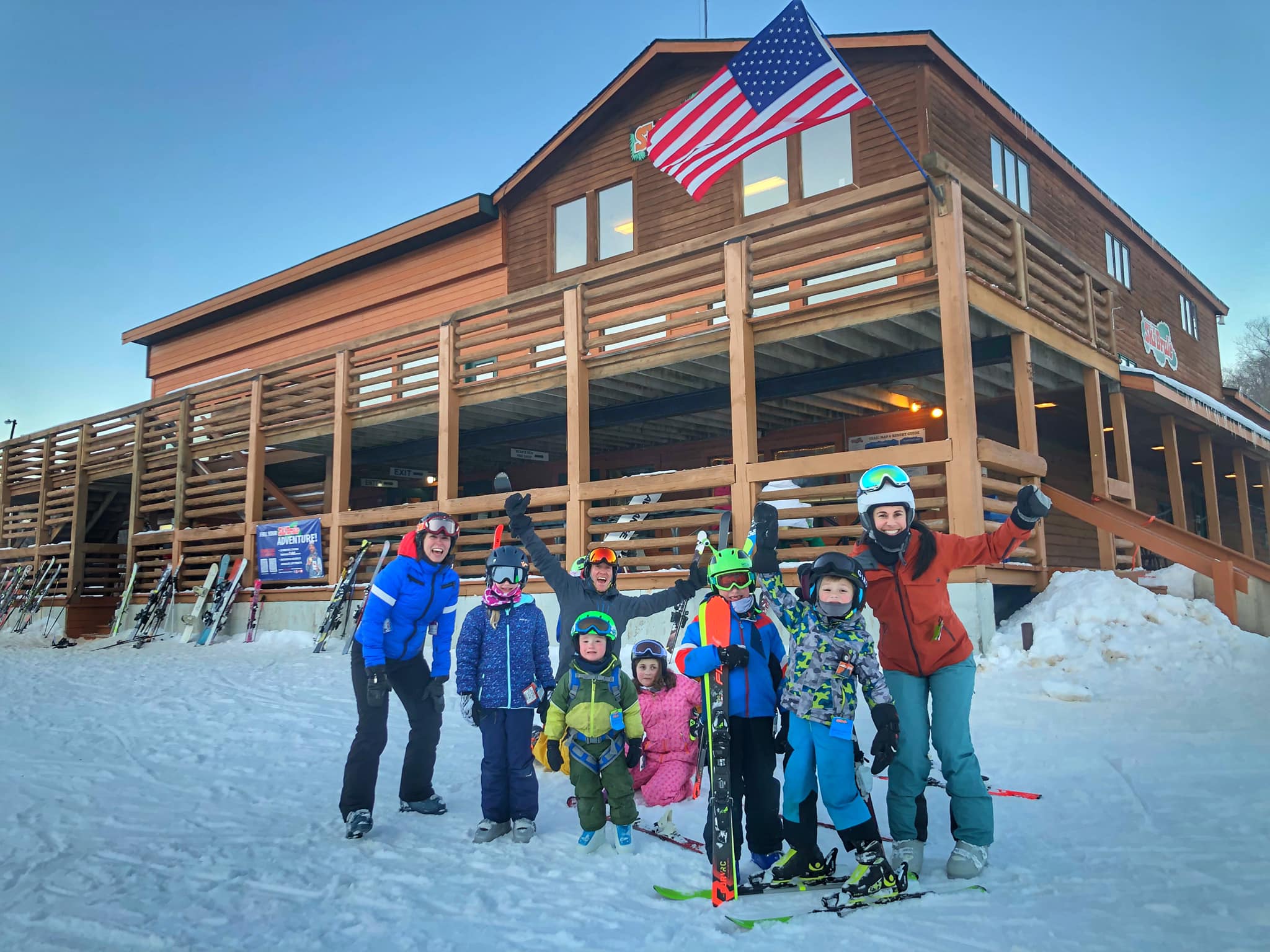 Moms in kids infront of ski Brule looking jolly in full gear