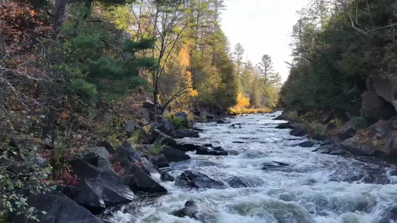 Whitewater breaking over dark boulders at Horserace Rapids in October