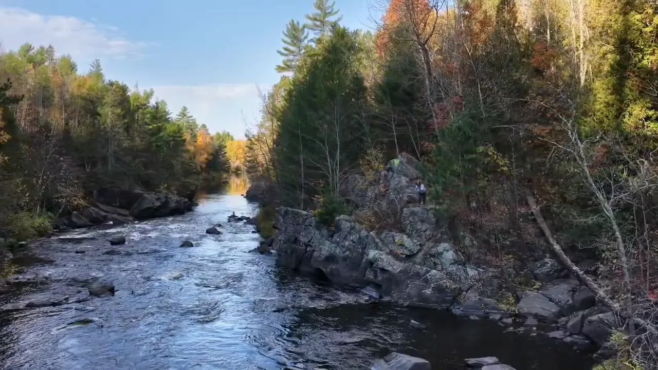 Rocky shoreline and fall trees along the Paint River at Horserace Rapids