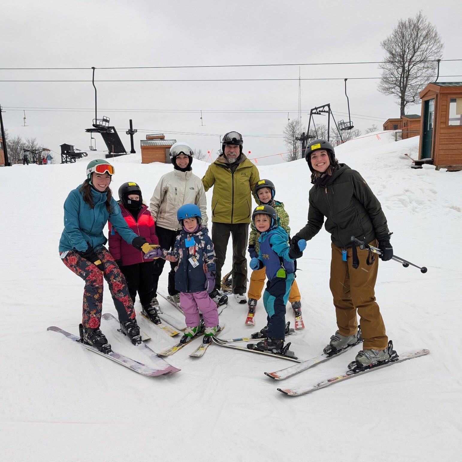A smiling family with children posing together in ski gear on a snowy slope at Ski Brule, Iron County, Michigan.